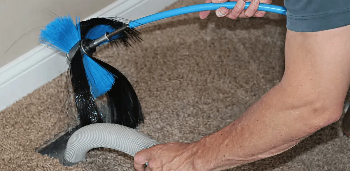 Dryer vent cleaning technician brushing lint from a vent line in Tampa, FL